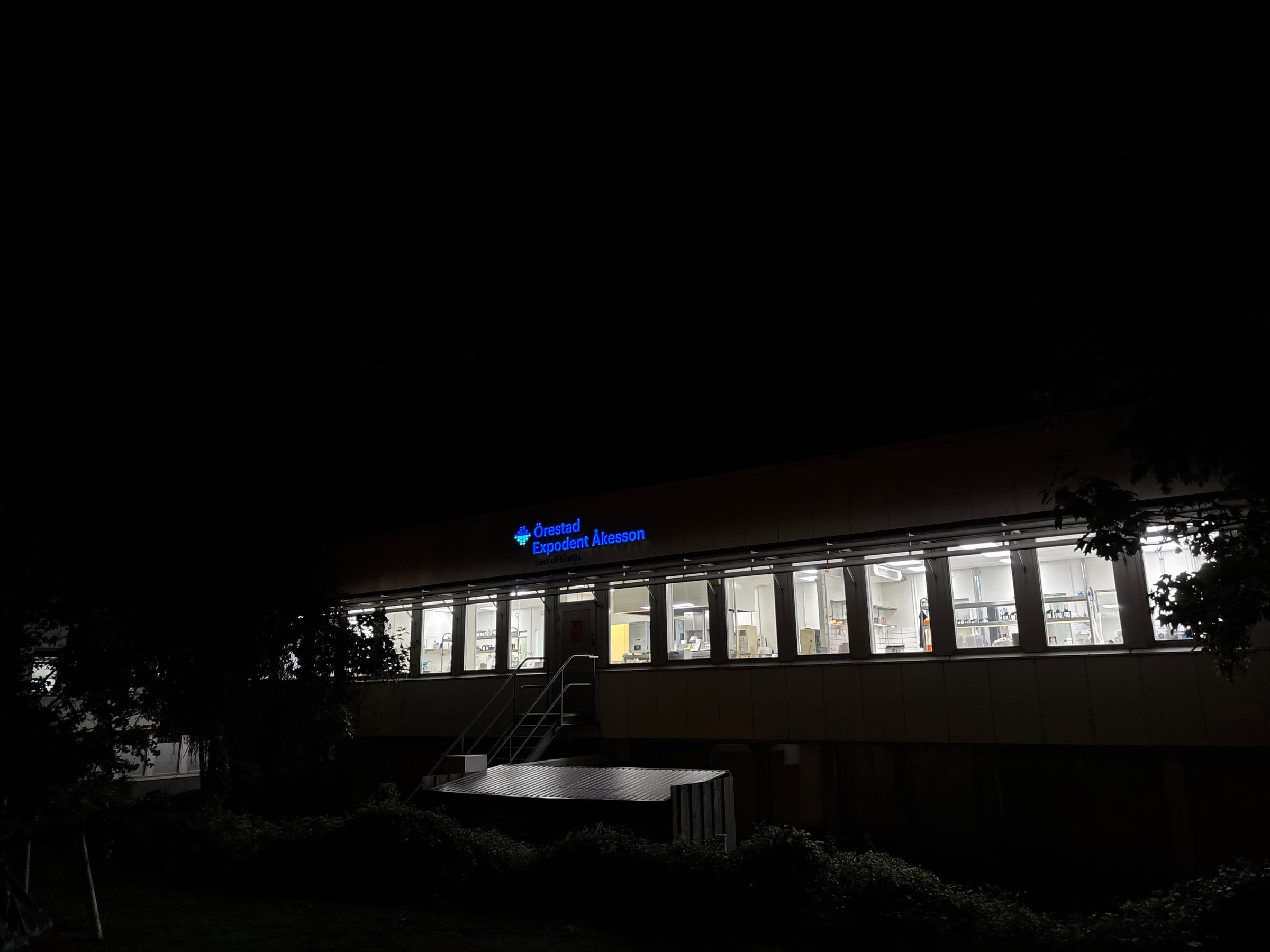 Fasadskylt med blå 3D LED-bokstäver för Örestad Expodent Åkesson i Limhamn, Malmö – belyst skylt ovanför fönsterbandet på kvällen