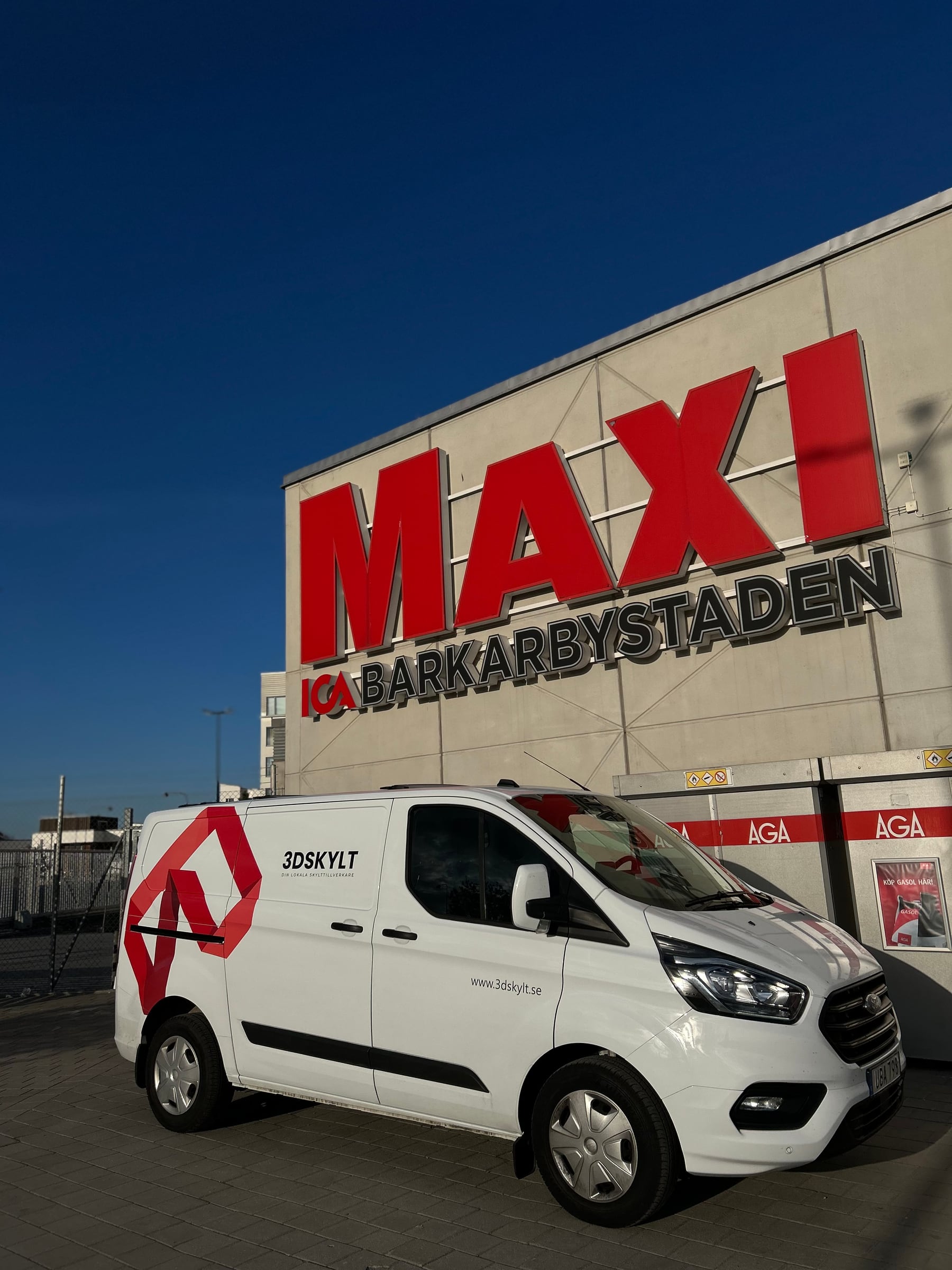 Fasadskylt för ICA Maxi Barkarbystaden i Järfälla – röda MAXI-bokstäver i 3D högt på fasaden, med 3D Skylts servicebil framför