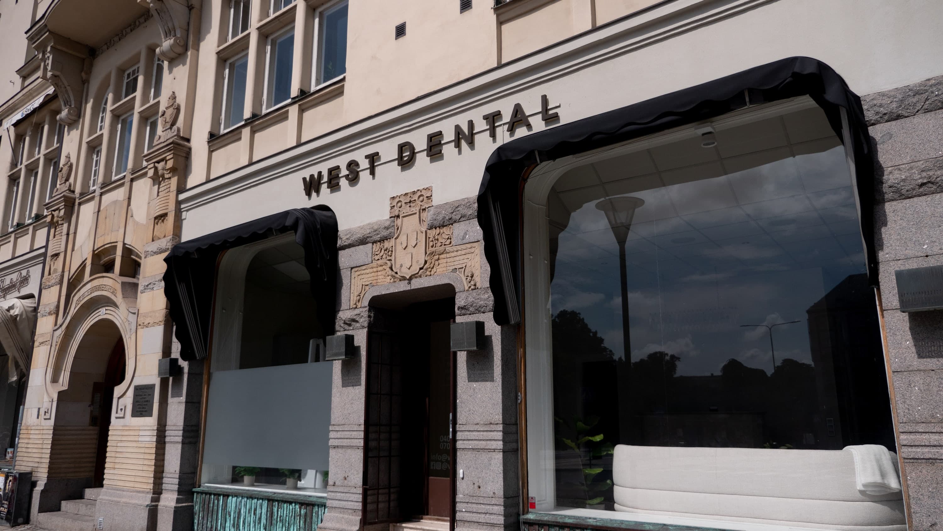 Fasadskylt för West Dental på stenfasad