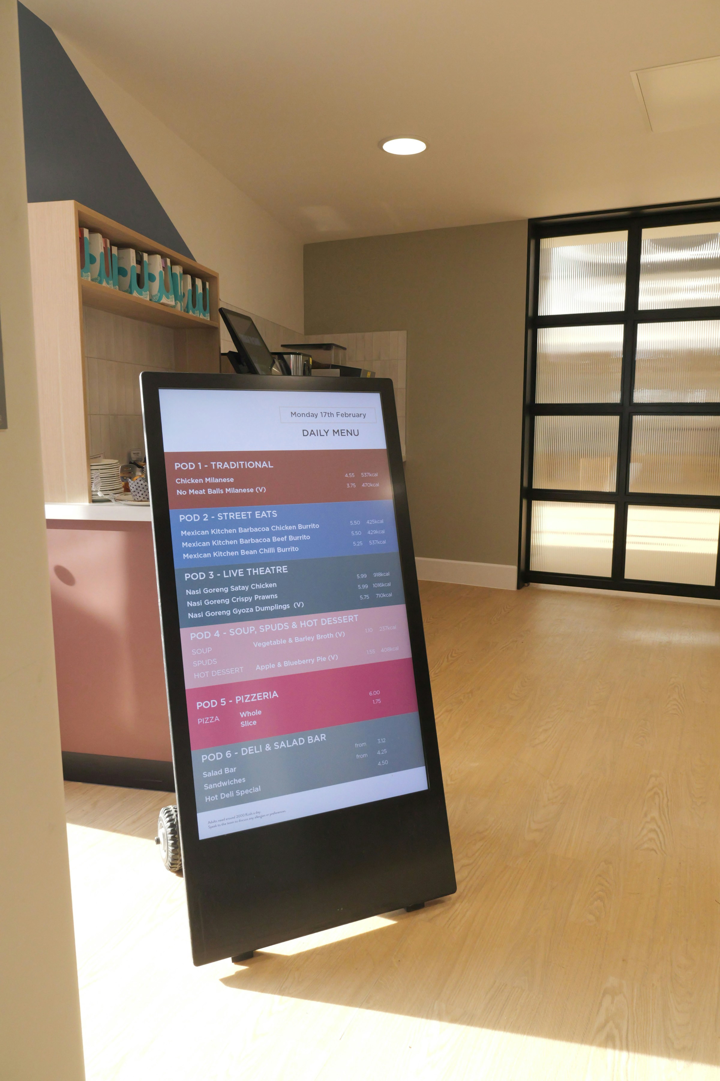 Exempelbild: digital signage – fristående menyskärm på hjul i en modern matsal