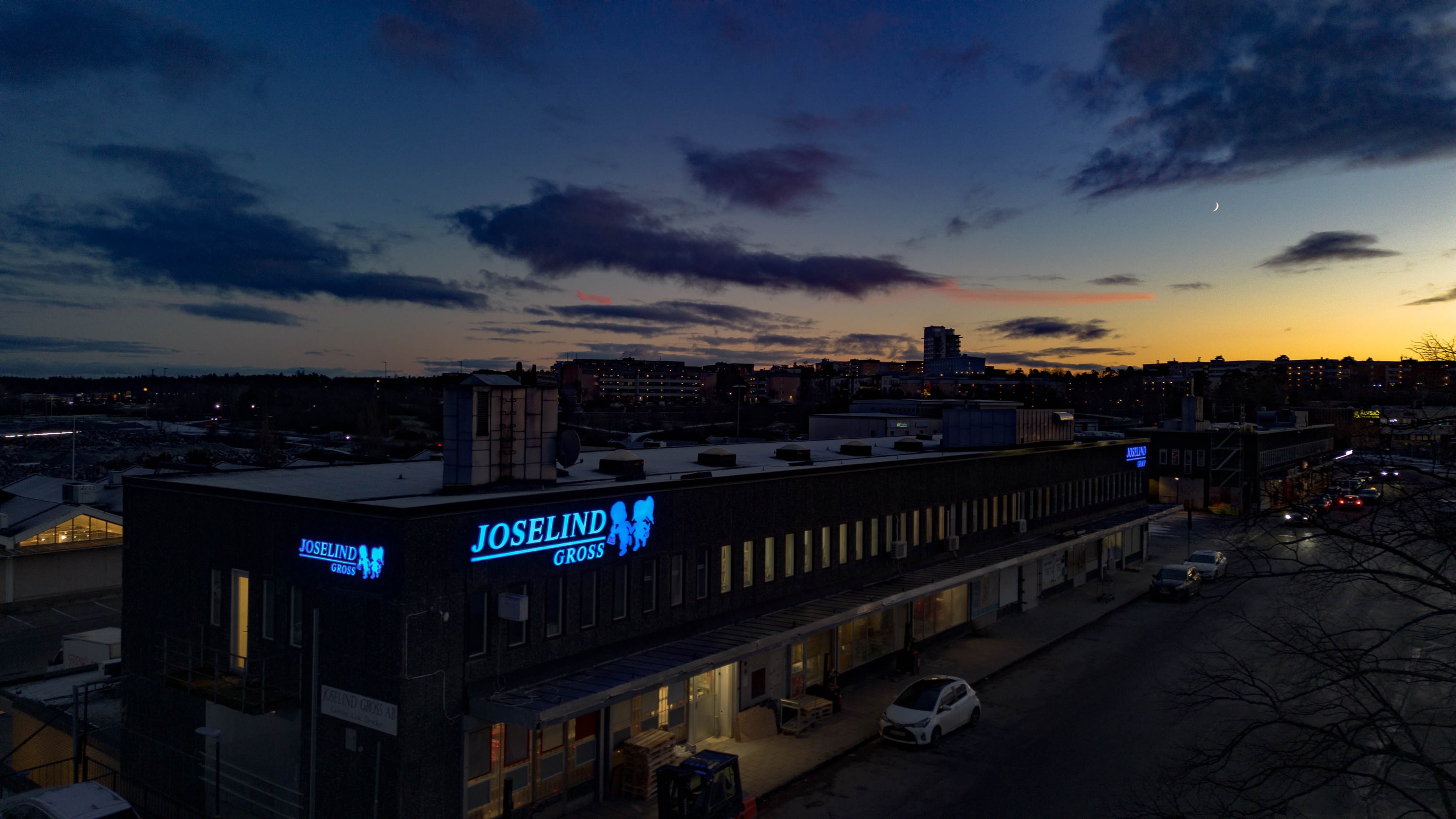 Belyst fasadskylt för Joselind Gross i skymningen