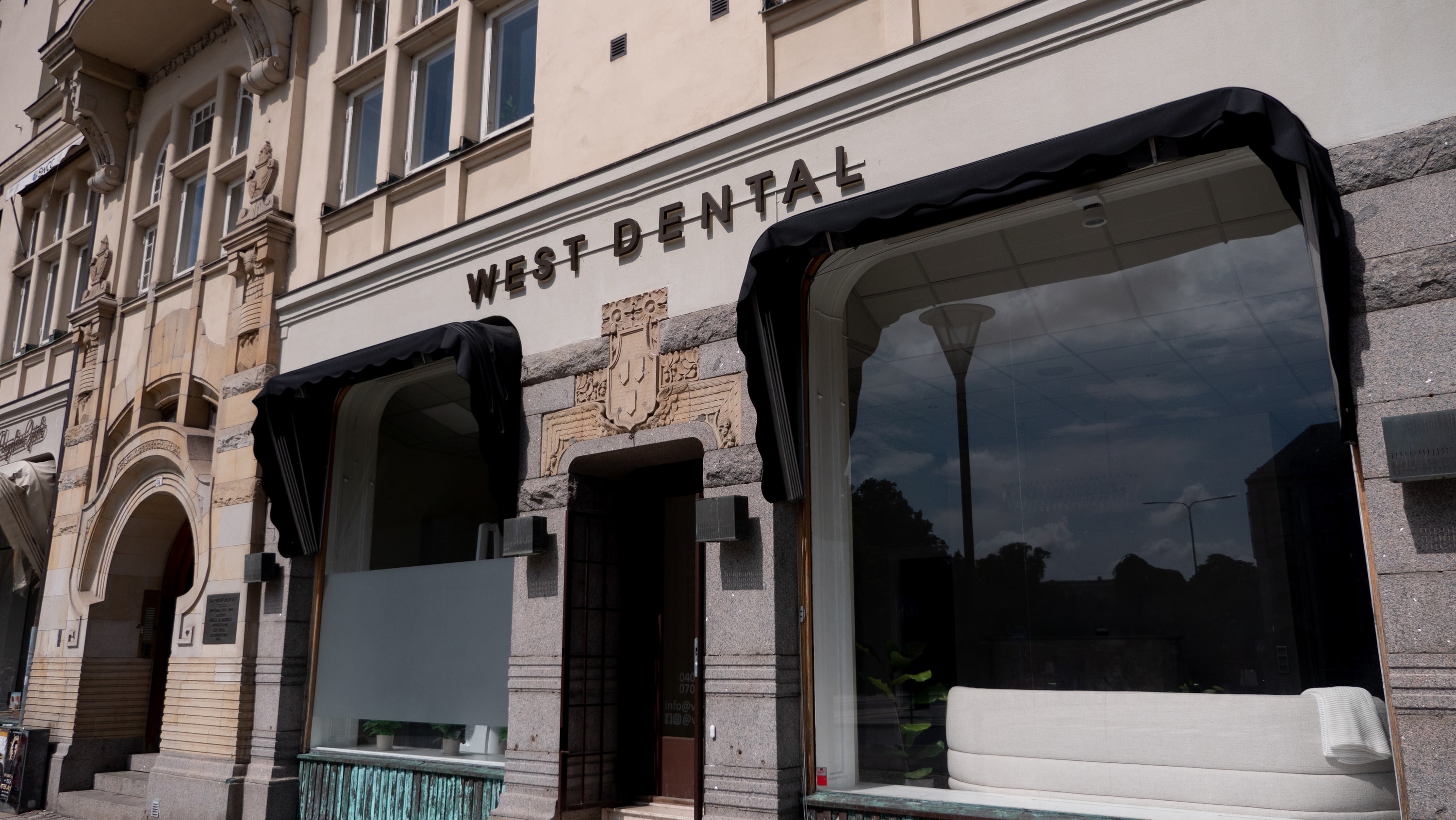 Fasadskylt för West Dental på stenfasad